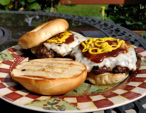 A pair of hamburgers resting on a plate.