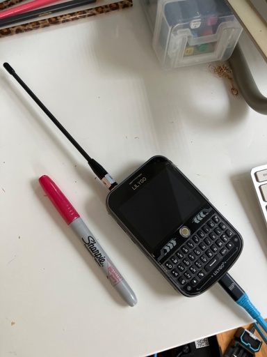 A handheld texting device with a physical keyboard and a short external antenna. 