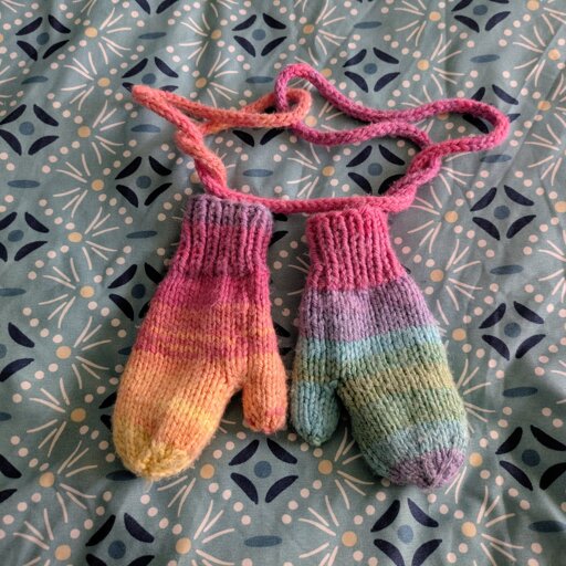 Moufles en laine multicolore posées sur un tissu