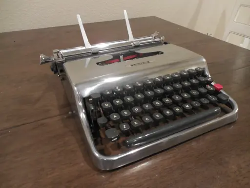 A diagonal view of a chrome-finish Olivetti Lettera 22 typewriter.
