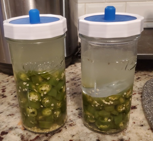 A picture of two jars of chopped peppers submerged in brine